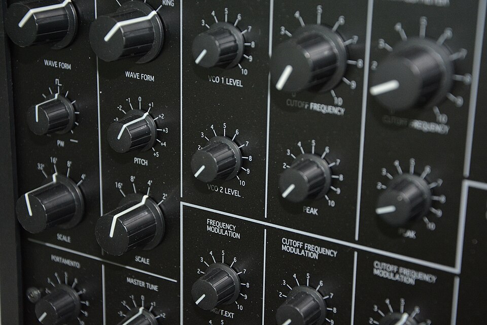 Rows of black knobs on a synthesizer panel